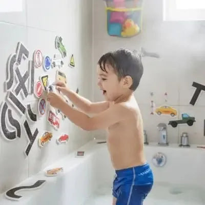 Enfant s'amuse avec décorations adhésives sur mur de bain