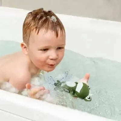 Jeune enfant éclabousse joyeusement avec animal aquatique flottant
