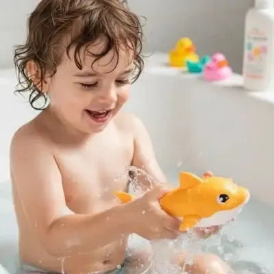 Enfant éclaboussant joyeusement avec jouet poisson vibrant.