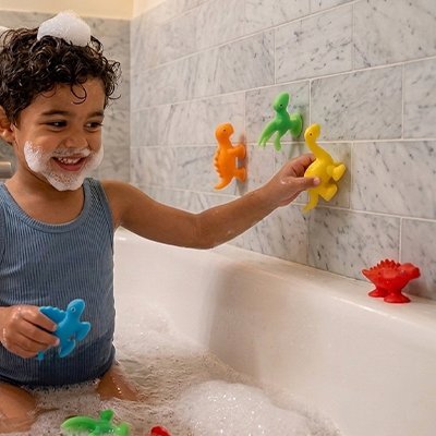 Enfant s'amusant avec figurines colorées dans la baignoire