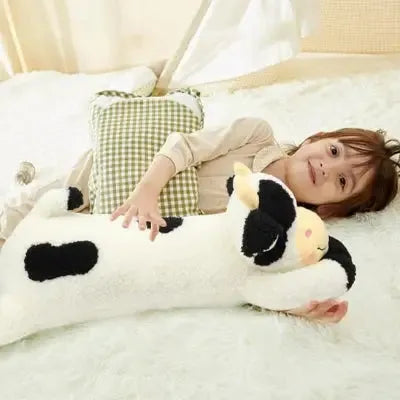 Enfant souriant avec jouet bovin en tissu moelleux