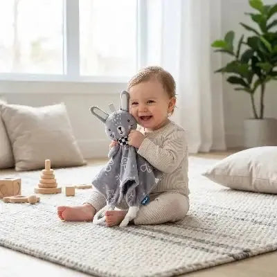 Doudou lapin dans les mains d'un bébé souriant