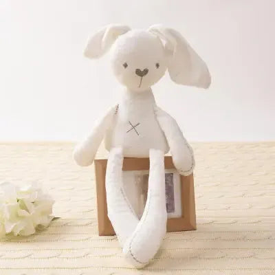 Jouet lapin blanc posé sur boîte en carton