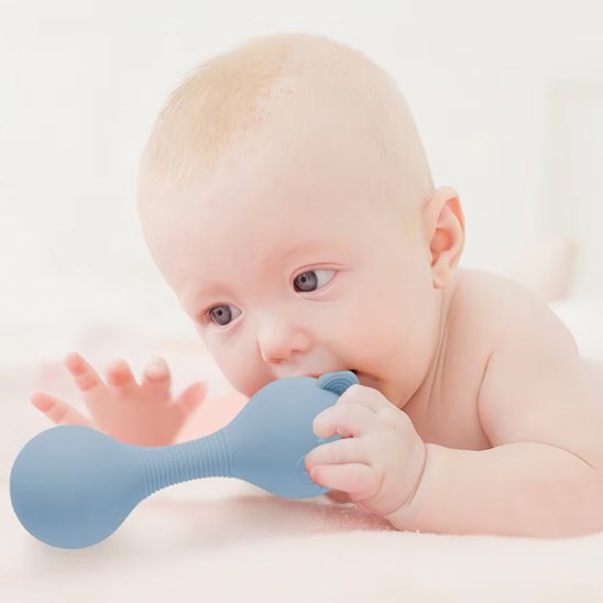 Hochet bébé bleu dans la main de bébé sur le ventre