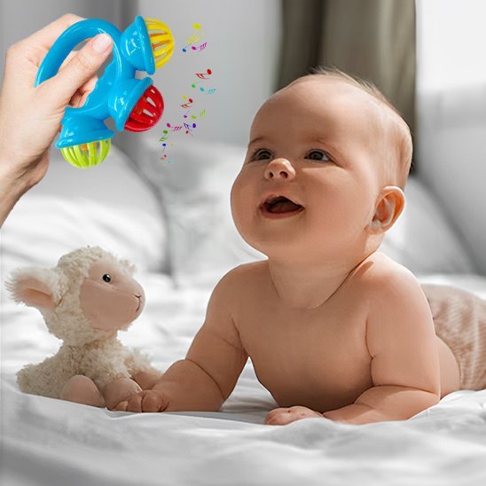 Hochet bébé musique bébé couché sur le ventre sur le lit
