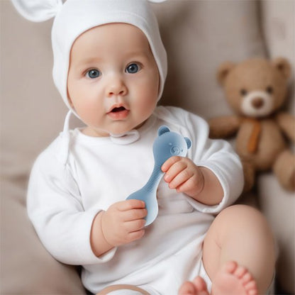 Hochet bébé ourson dans les mains sur le sofa