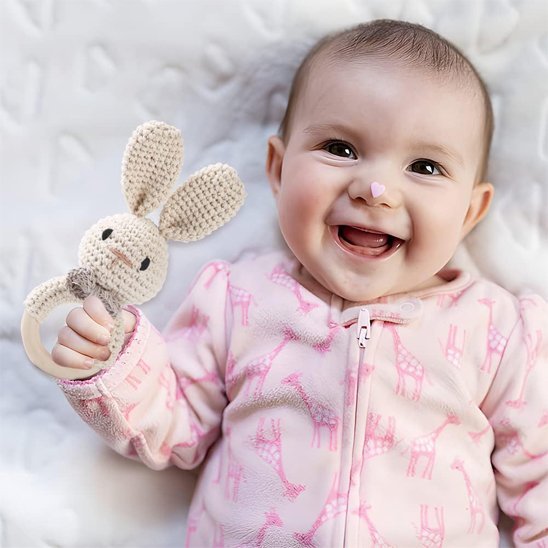 Hochet crochet lapin beige dans les mains de bébé qui rit