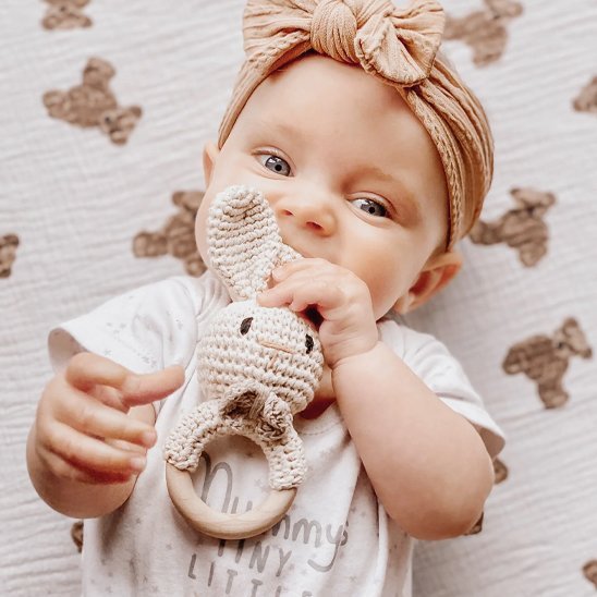 Hochet crochet lapin dans la bouche d'une petite fille
