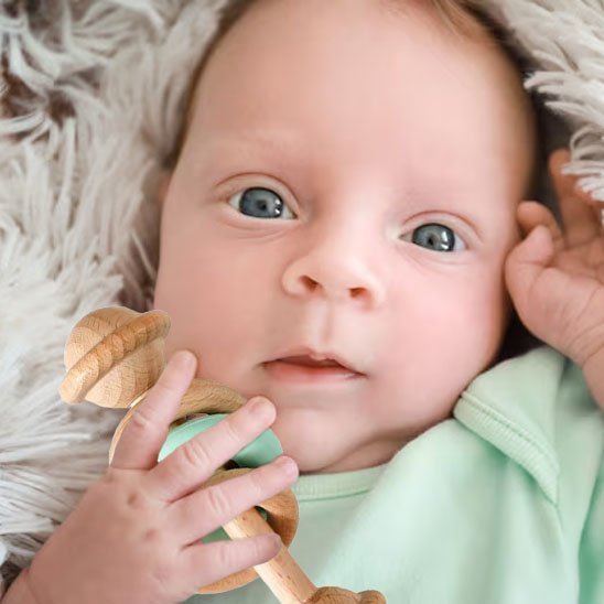 Hochet en bois avec bébé éveillé
