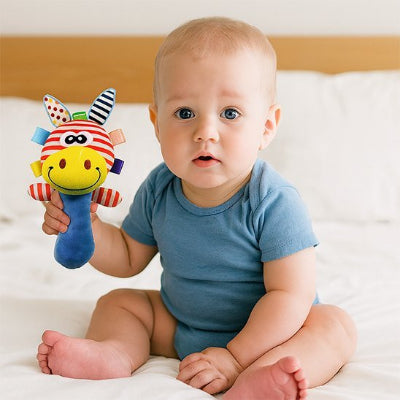 HOCHET POUR BEBE assis sur le lit zèbre à la main 