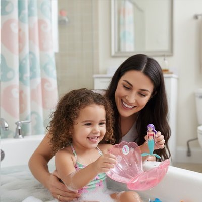 Jouet de bain​ avec jeune fille souriante et son coquillage