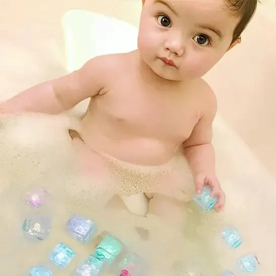 Bébé s'amuse avec cubes flottants lumineux dans l'eau