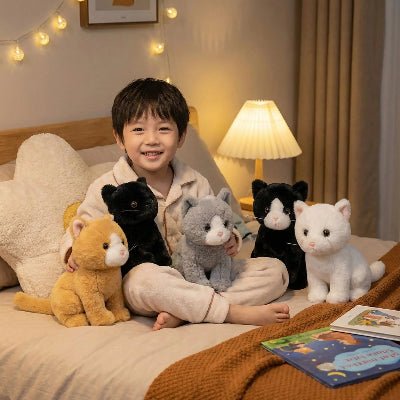 Cinq peluche chat et un garçon sur le lit