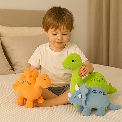 Peluche dinosaure avec jeune garçon sur le lit