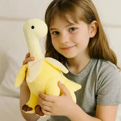 peluche dinosaure jaune tenue par une enfant souriante