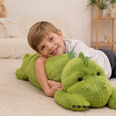Peluche dinosaure lestée enlacé des bras d'un garçon