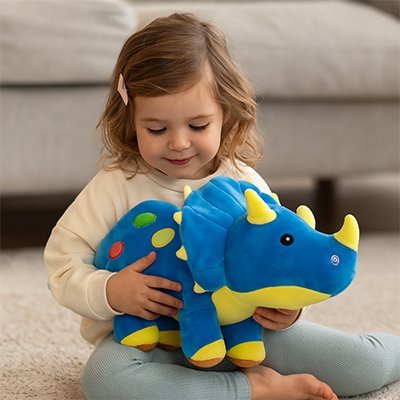 Peluche dinosaure bleu dans les mains d'une petite fille