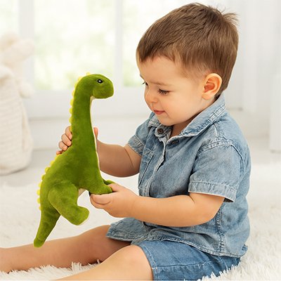 Peluche dinosaure vert dans les mains d'un garçon