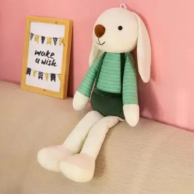 Jouet en forme de lapin posé sur canapé beige