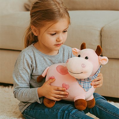 Peluche vache rose avec une jeune fille