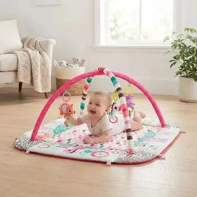 Environnement interactif pour bébé avec arches colorées et jouets.