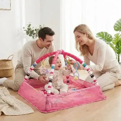 Famille heureuse autour d'un espace de jeu interactif pour bébé