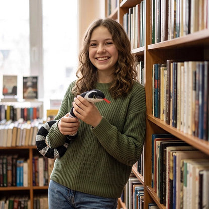 Une fille à la bibliothèque avec sa peluche serpent